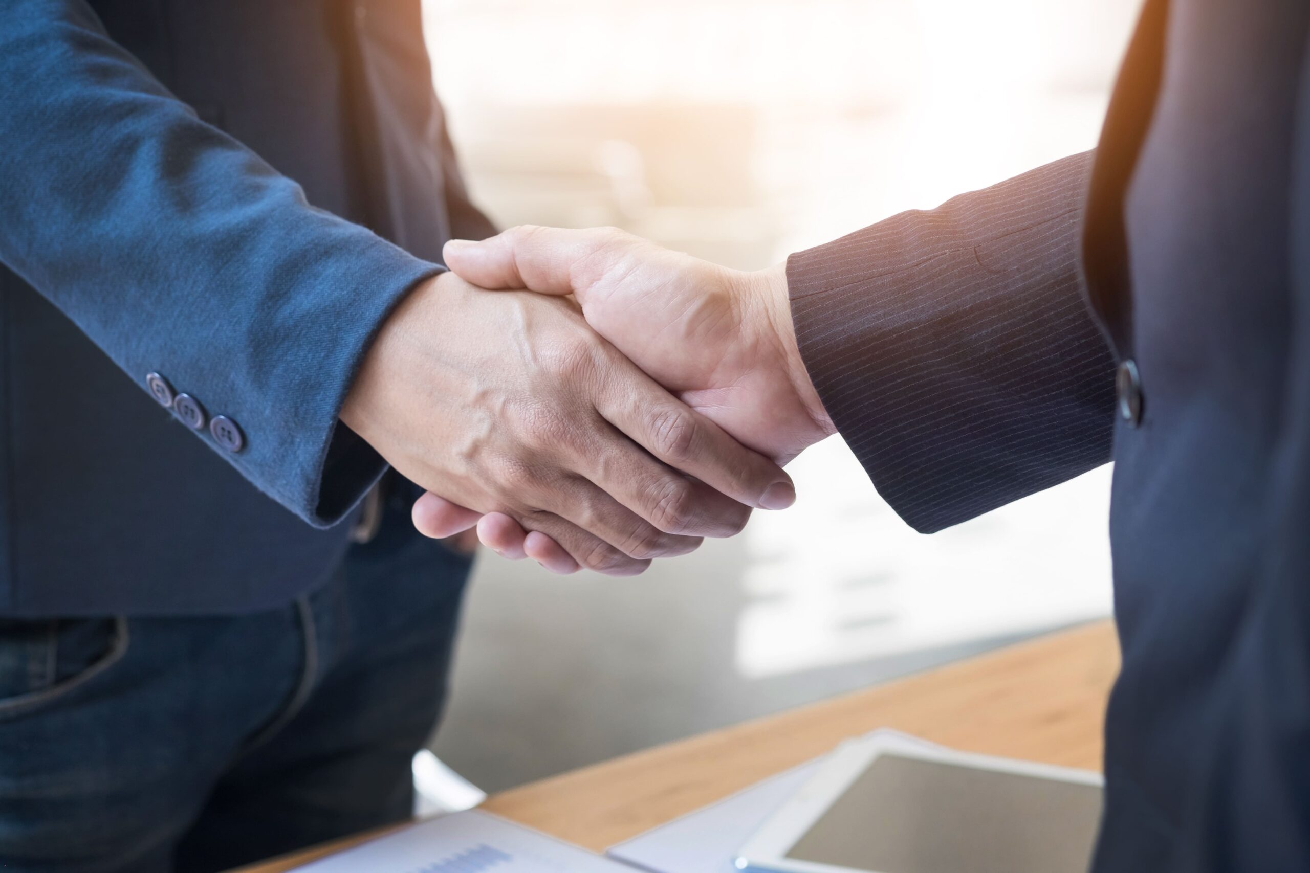 dos-hombres-negocios-confia-estrechar-mano-reunion-oficina-exito-trato-saludo-concepto-socio (1)